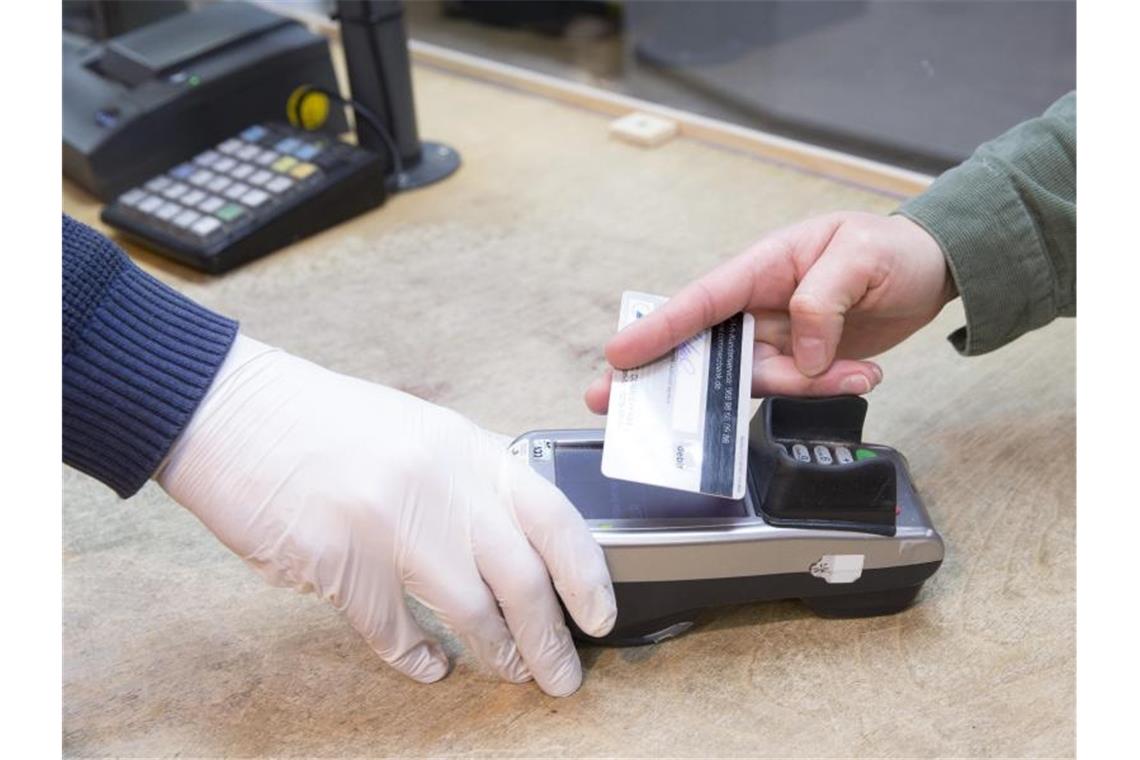 Girocard mit Rekordzahlen - Schub für kontaktloses Bezahlen Ein Verkäufer hält dem Kunden das EC- Lesegerät zum kontaktlosen Bezahlen hin. Foto: Georg Wenzel/dpa-Zentralbild/dpa