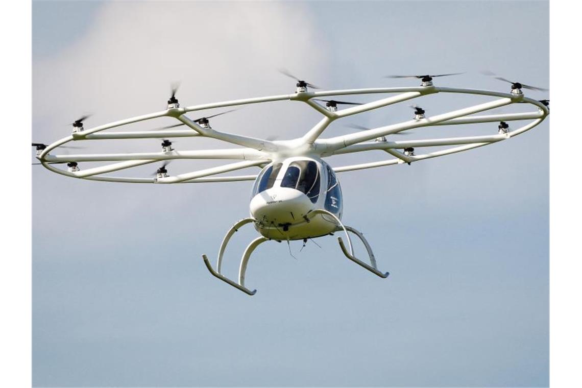 Ein Volocopter fliegt in einer europäischen Innenstadt. Foto: Christoph Schmidt/dpa/Archivbild