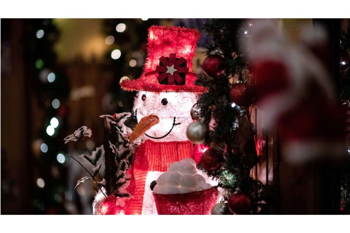 Ein von innen beleuchteter Deko-Schneemann steht im Flur der weihnachtlich dekorierten Wohnung