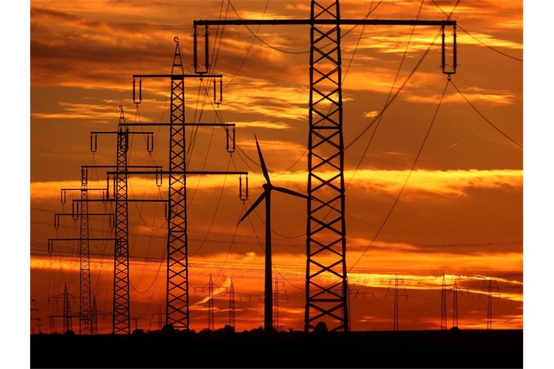 Klima-Allianz: Erheblicher Nachholbedarf in Wahlprogrammen Ein Windrad steht im Abendlicht neben den Masten einer Stromtrasse. Foto: Karl-Josef Hildenbrand/dpa