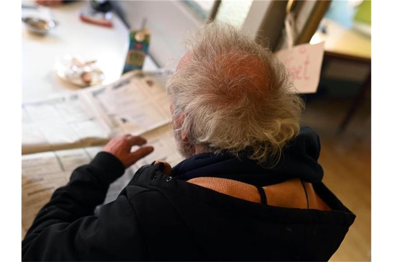 Ein Wohnungsloser liest in der Einrichtung „Tagestreff Tür“ der Diakonie Karlsruhe eine Zeitung. Foto: Uli Deck/dpa/Archivbild