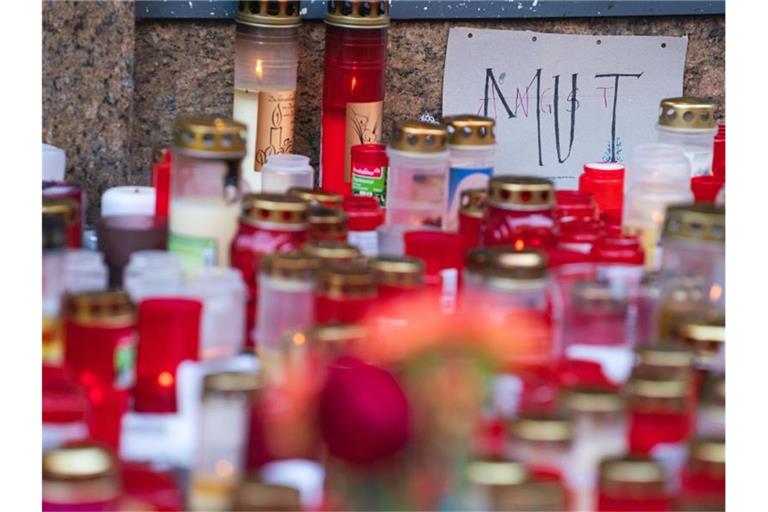 Ein Zettel mit der Aufschrift „Mut“ und "Angst" liegt inmitten von Trauerkerzen in Würzburg. Foto: Nicolas Armer/dpa