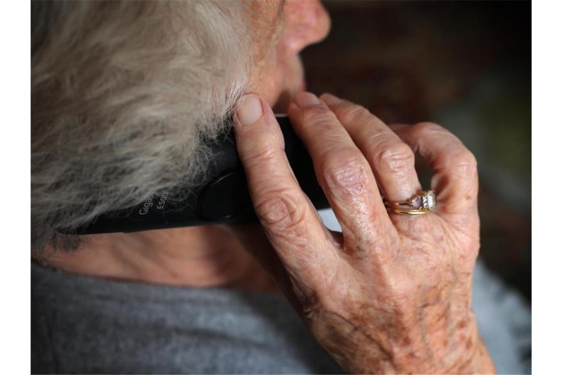 Eine ältere Frau telefoniert mit einem schnurlosen Festnetztelefon. Foto: Karl-Josef Hildenbrand/dpa/Symbolbild