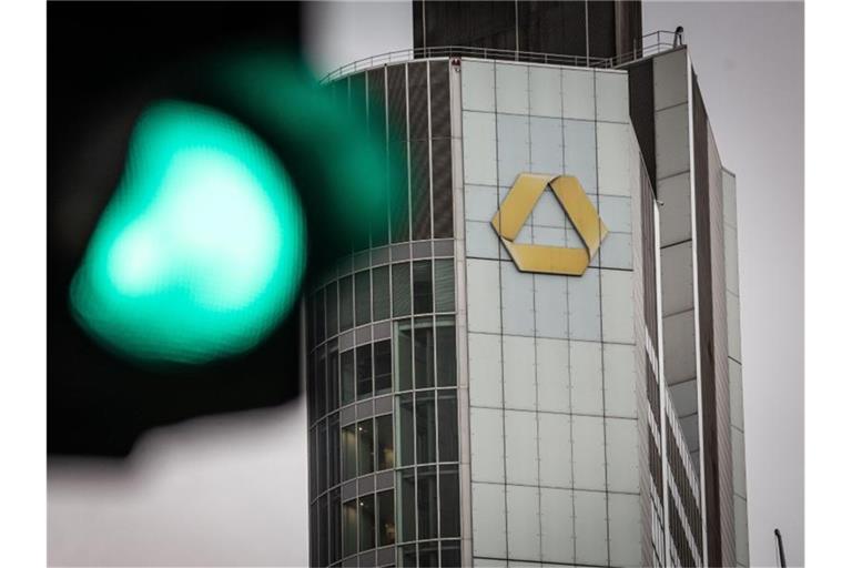 Eine Ampel steht auf Grün vor dem Logo an der Zentrale der Commerzbank. Foto: Frank Rumpenhorst/dpa/Symbolbild