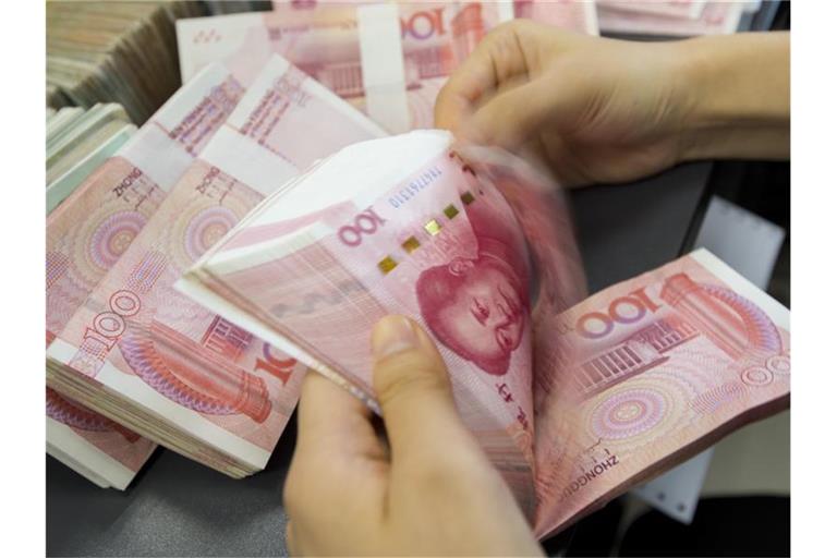 Eine Bankangestellte zählt ein Bündel Geldscheine. Die chinesische Notenbank hat Maßnahmen gegen die Stärke der heimischen Währung Yuan ergriffen. Foto: Xu Jingbo/SIPA Asia via ZUMA Wire/dpa