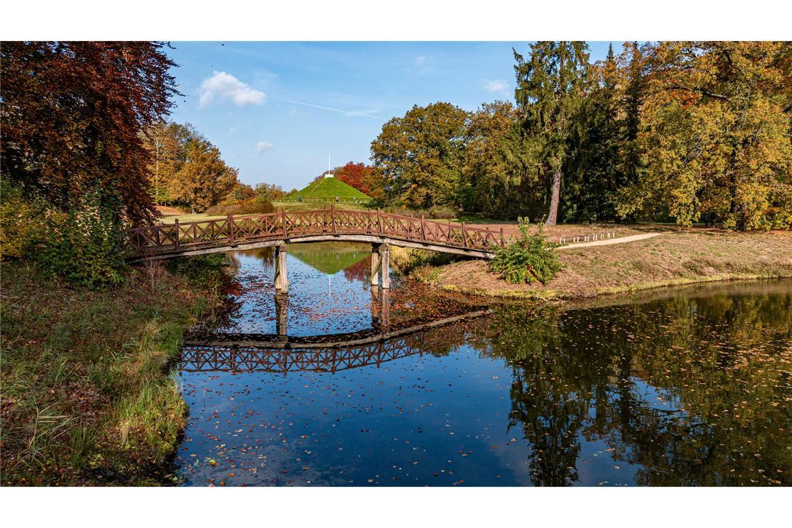 Eine Brücke im Branitzer Park spiegelt sich im Wasser.