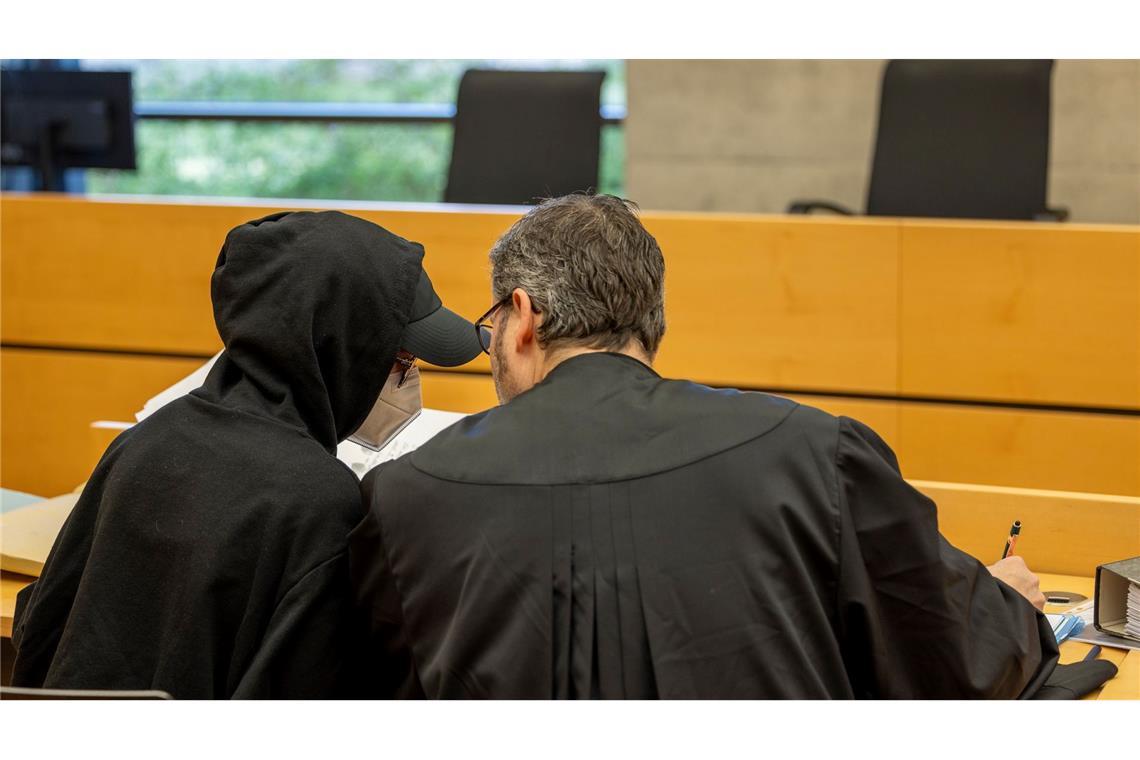 Eine der beiden Angeklagten (l) unterhält sich mit ihrem Rechtsanwalt im Sitzungssaal im Landgericht.