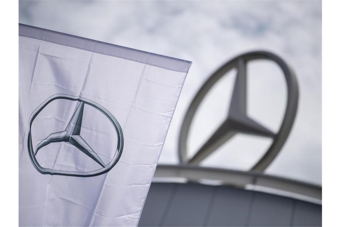 Eine Fahne mit dem Logo der Marke Mercedes-Benz weht vor einem Showroom der Firma. Foto: Sebastian Gollnow/dpa/Symbolbild