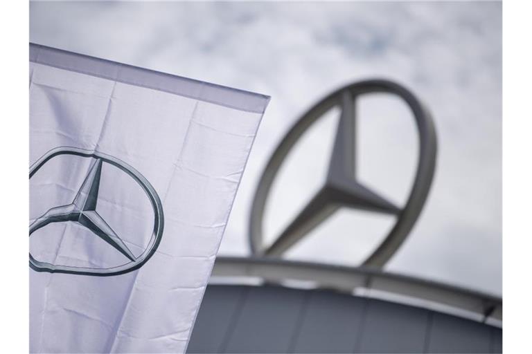 Eine Fahne mit dem Logo der Marke Mercedes-Benz weht vor einem Showroom der Firma. Foto: Sebastian Gollnow/dpa/Symbolbild