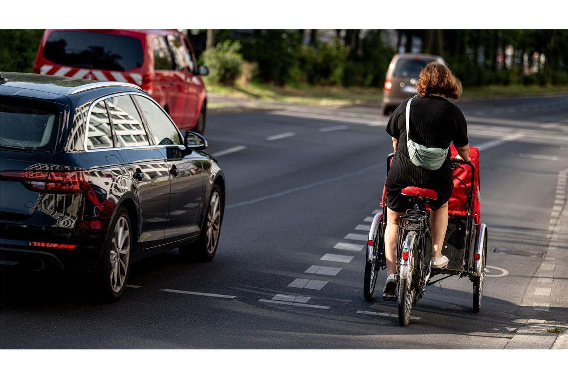 Eine Fahrradfahrerin fährt mit einem Lastenfahrrad. Diese werden oft für den Transport von Kindern benutzt.