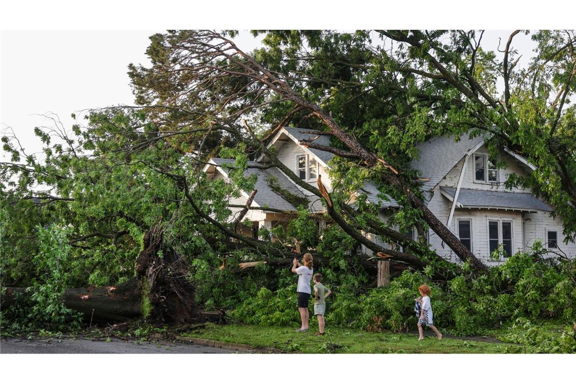 Eine Familie sieht sich die Schäden am Haus ihres Nachbarn in Oklahoma an: Starke Stürme hinterließen in mehreren US-Bundesstaaten eine  Spur der Verwüstung.