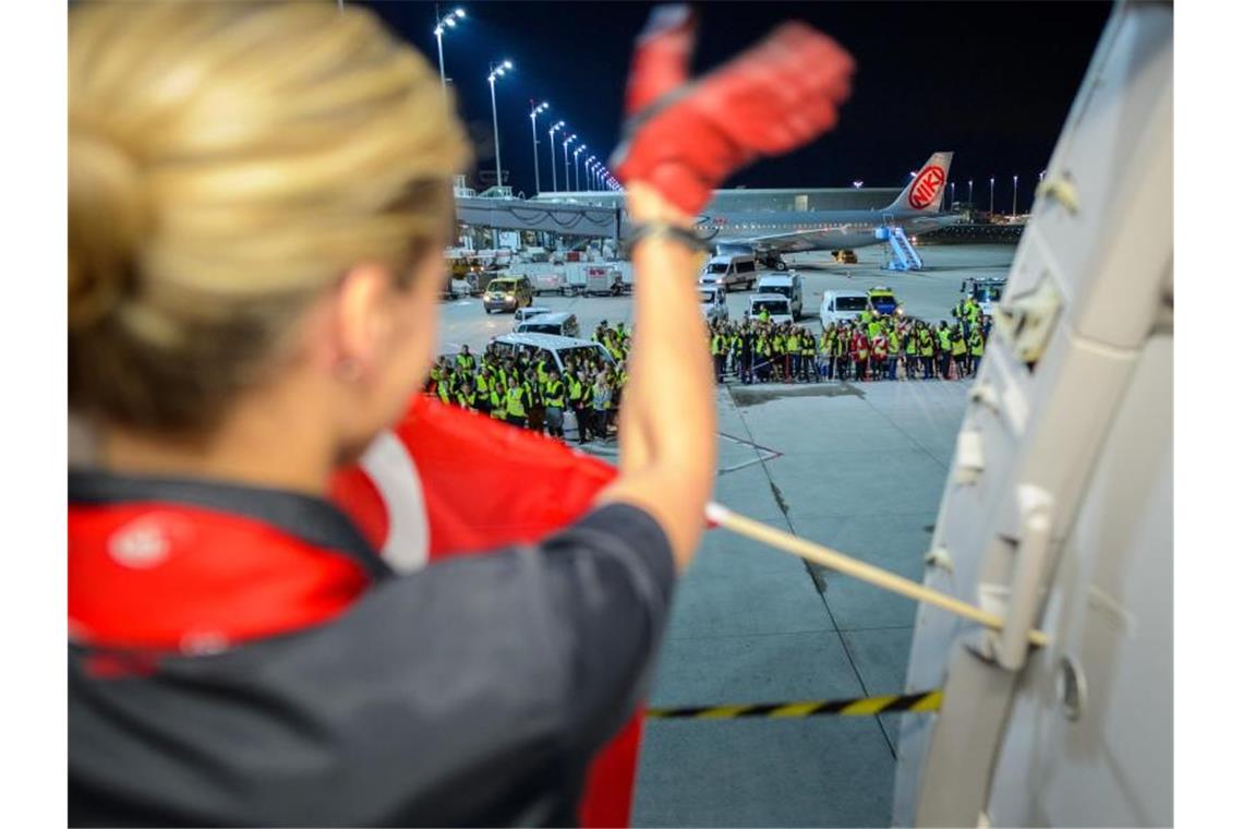 Flugbegleiter von Pleite-Airline Air Berlin gehen leer aus Eine Flugbegleiterin der Fluggesellschaft Air Berlin winkt am auf dem Flughafen in München weiteren Mitarbeitern der Airline vor dem letzten Flug zur Verabschiedung. Foto: Gregor Fischer/dpa