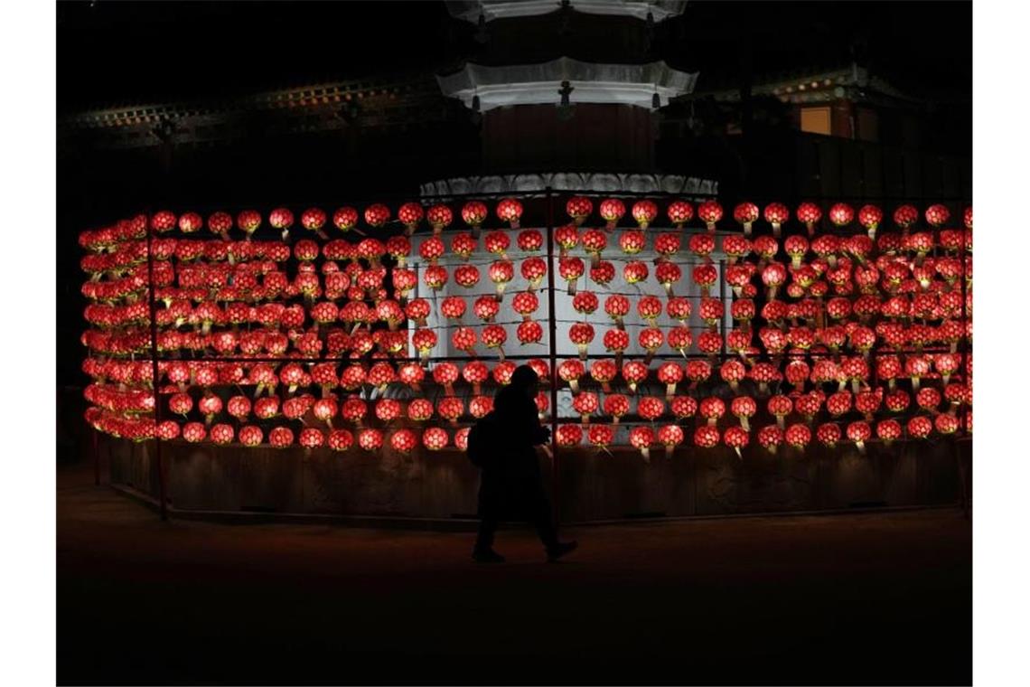 Das neue Jahr startet erneut eher ruhig - Milde Temperaturen Eine Frau betet am Silvesterabend vor Laternen im Jogye-Tempel in Seoul. Foto: Lee Jin-Man/AP/dpa