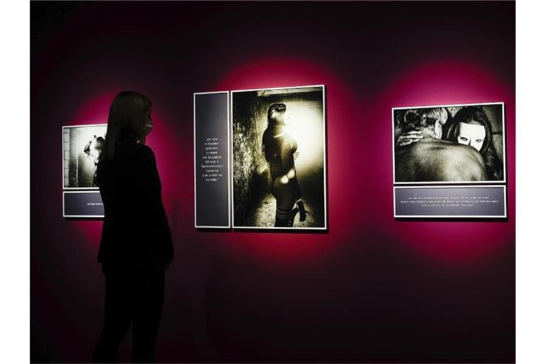 Eine Frau betrachtet Fotografien in der Sonderausstellung „gesichtslos – Frauen in der Prostitution“. Foto: Uwe Anspach/dpa