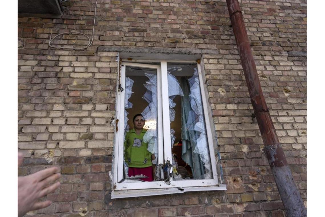 Krieg gegen die Ukraine: So ist die Lage Eine Frau blickt durch ein zerstörtes Fenster ihrer durch Beschuss beschädigten Wohnung in Kiew. Foto: Rodrigo Abd/AP/dpa