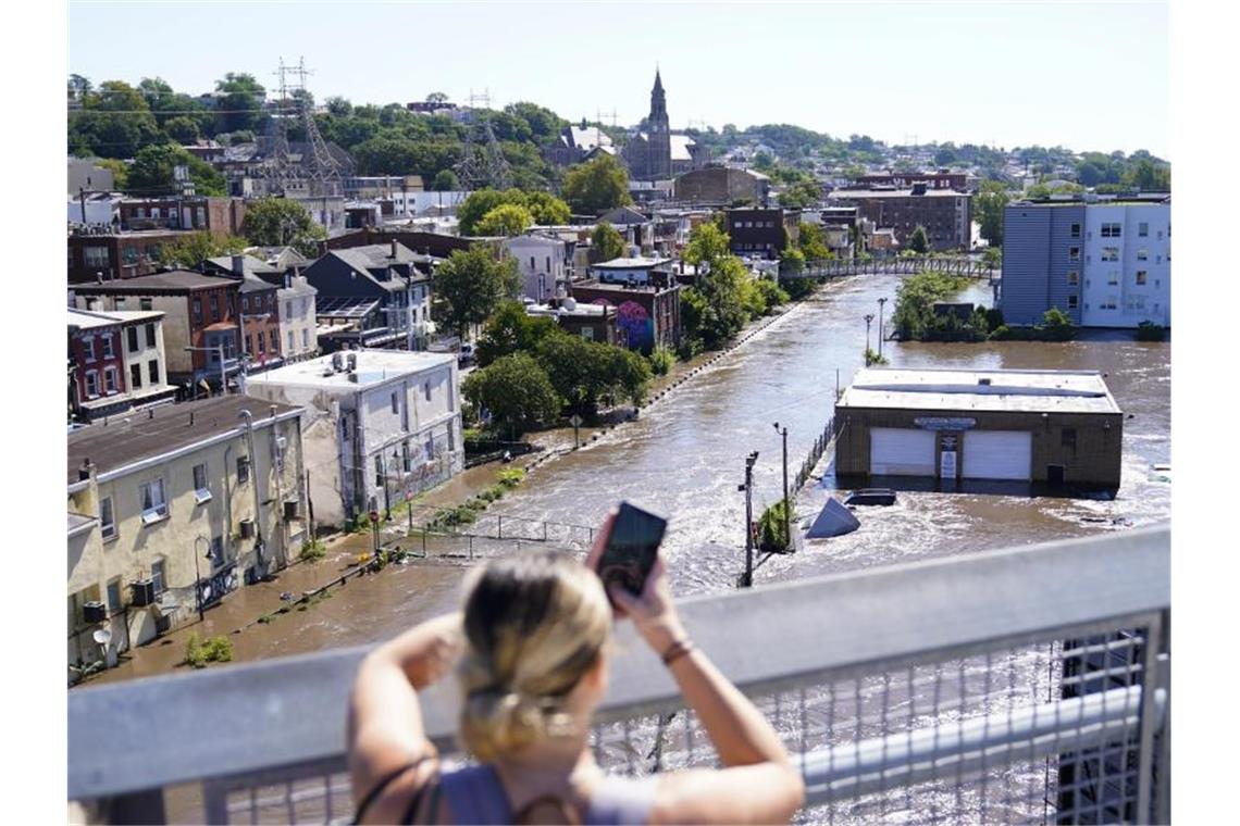 Dutzende Tote nach Hurrikan „Ida“ und Starkregen in den USA Eine Frau fotografiert das Hochwasser in Philadelphia. Foto: Matt Rourke/AP/dpa