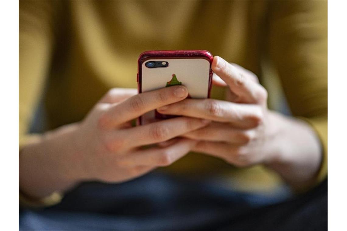 Eine Frau hält ein Smartphone in der Hand. Foto: Fabian Sommer/dpa/Illustration