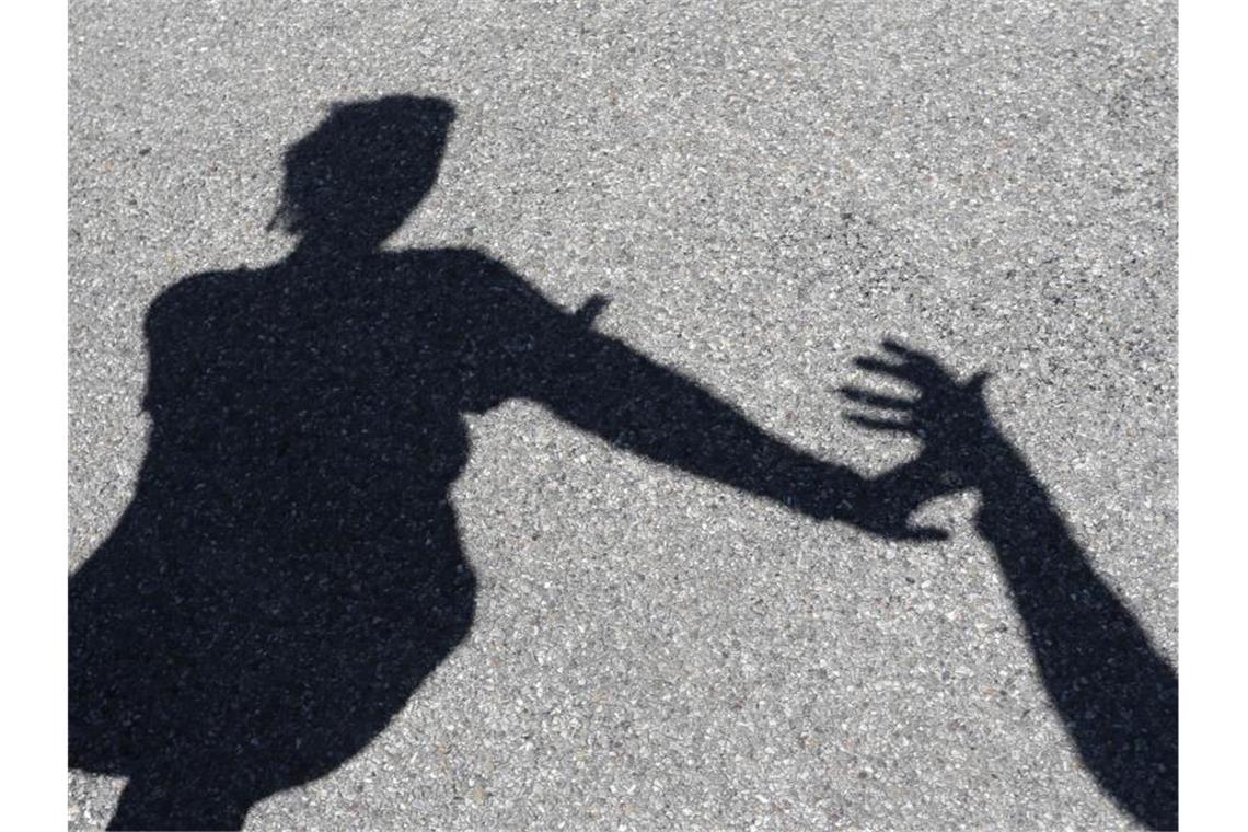 Anlaufstelle für Opfer sexualisierter Gewalt geschaffen Eine Frau, nach der ein Mann greift, beide im Schattenriss. Foto: Karl-Josef Hildenbrand/dpa/Symbolbild