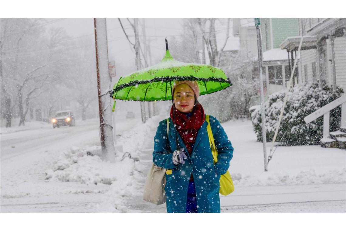 Eine Frau schützt sich in Bellows Falls in Vermont mit einem Schirm vor den Schneeflocken.