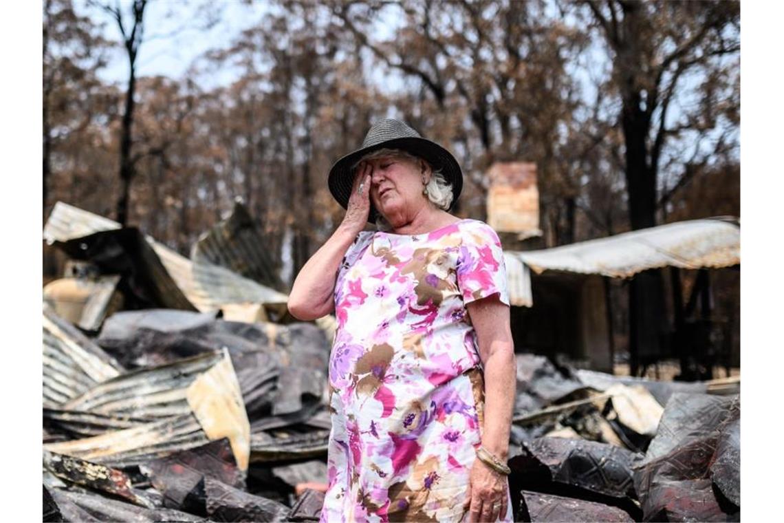 Regen in Australien: Urzeit-Bäume vor Buschbränden gerettet Eine Frau steht im Ort Mogo vor den Überresten ihres Geschäfts, das an Silvester abgebrannt ist. Foto: James Gourley/AAP/dpa