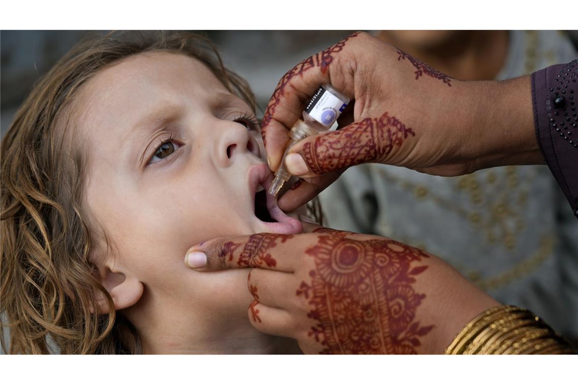 Eine Gesundheitshelferin verabreicht einem Kind in einem Stadtteil von Lahore in Pakistan eine Dosis mit Polio-Impfstoff.