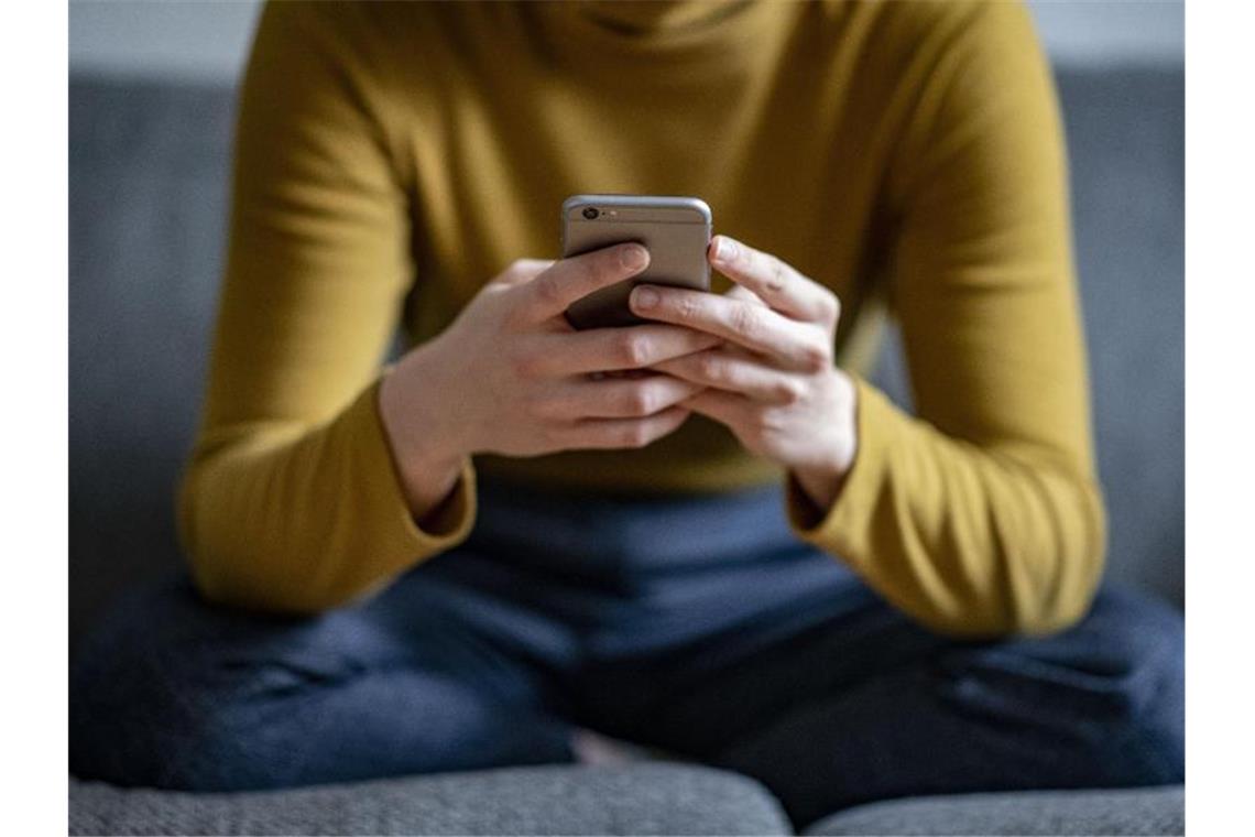 Eine junge Frau hält ein Smartphone in der Hand. Foto: Fabian Sommer/dpa/Archivbild