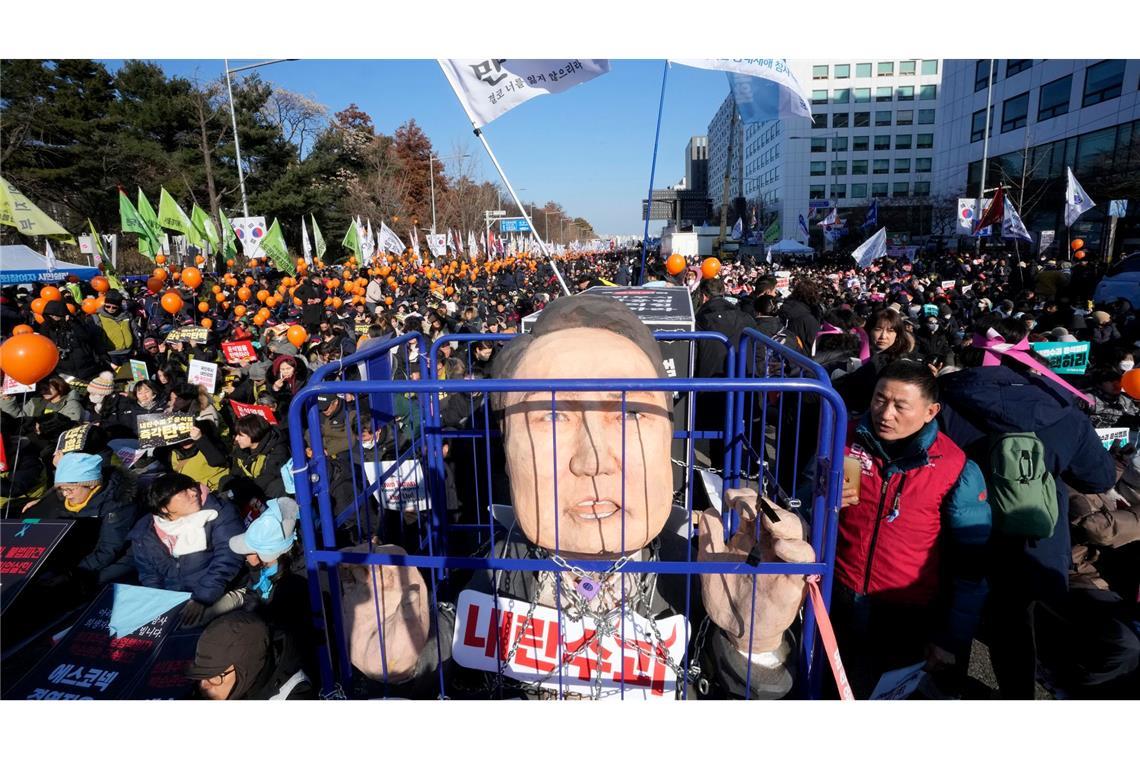 Eine Karikatur eines inhaftierten südkoreanischen Präsidenten Yoon Suk Yeol wird vor einer Kundgebung zur Forderung seiner Amtsenthebung vor der Nationalversammlung gezeigt. Ein zweiter Amtsenthebungsantrag gegen Yoon hat die benötigte Zweidrittelmehrheit in der Nationalversammlung erreicht.