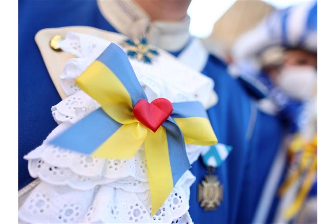 Eine Viertelmillion Menschen gegen den Krieg in Köln Eine Karnevalistin trägt eine Schleife in den ukrainischen Landesfarben bei der Friedensdemonstration am Rosenmontag. Foto: Rolf Vennenbernd/dpa