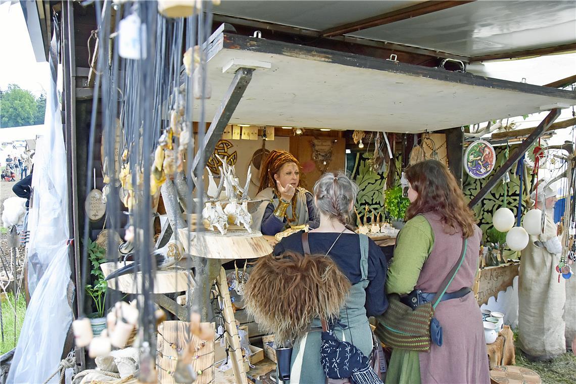 Eine keltische Händlerin bietet schamanisches Kunsthandwerk wie Ketten, Perlen, ...