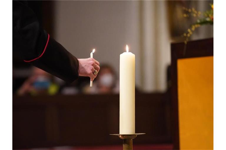 Eine Kerze wird während eines Gedenkgottesdienstes entzündet. Foto: Marcus Brandt/dpa/Archivbild