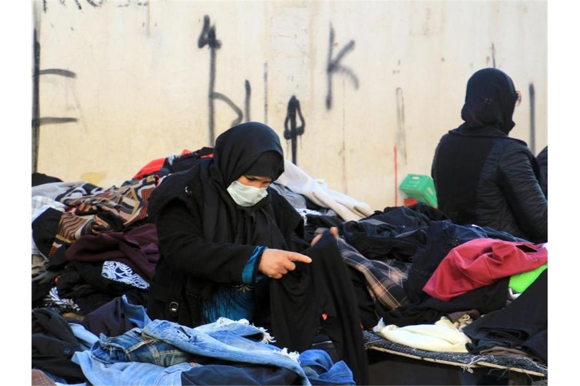 Kleidung: Afrika wird zur „Müllkippe des Westens“ Eine Kundin schaut sich gebrauchte Kleidungsstücke auf einem zentralen Markt in Tunesiens Hauptstadt an. Foto: Cindy Riechau/dpa