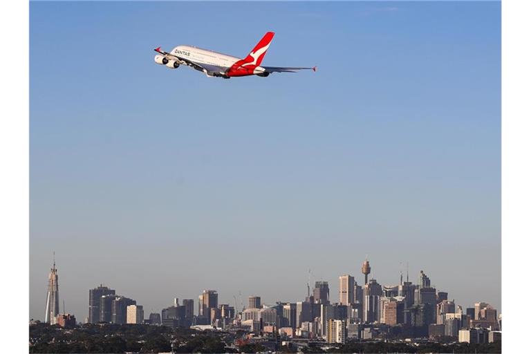 Eine Maschine der australischen Fluggesellschaft Qantas fliegt über Sydney. Foto: Bai Xuefei/Xinhua/dpa