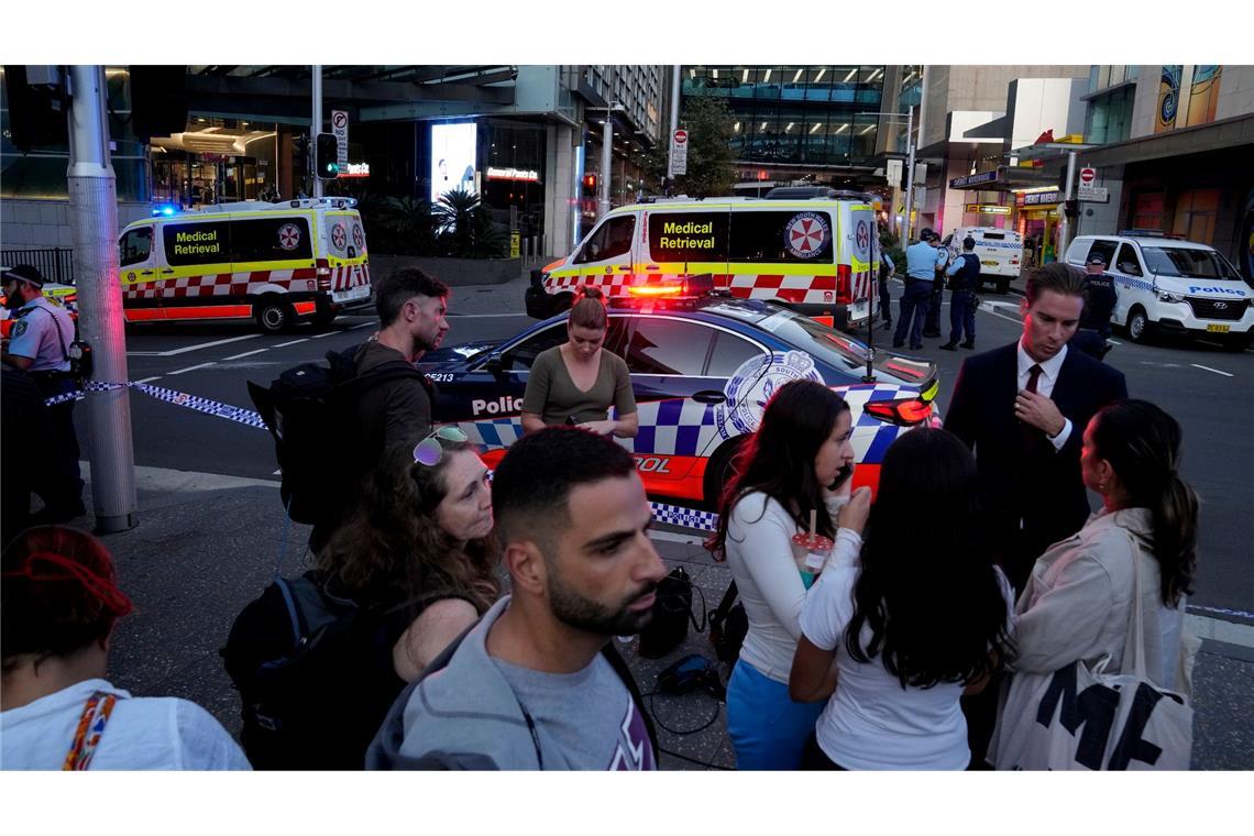 Eine Menschenmenge versammelt sich vor dem Westfield Shopping Centre. Medienberichten zufolge wurden in dem Einkaufszentrum in Sydney mehrere Menschen niedergestochen und eine Person von der Polizei erschossen.