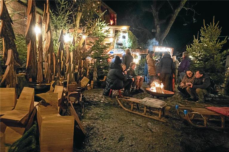 Eine mit Kissen gepolsterte Schlittenrunde rund um eine Feuerschale vor einem ausgesägten Nadelwald bietet eine besondere Kulisse, um die Leckereien des Großhöchberger Weihnachtsmarkts in aller Ruhe zu genießen. Foto: Alexander Becher