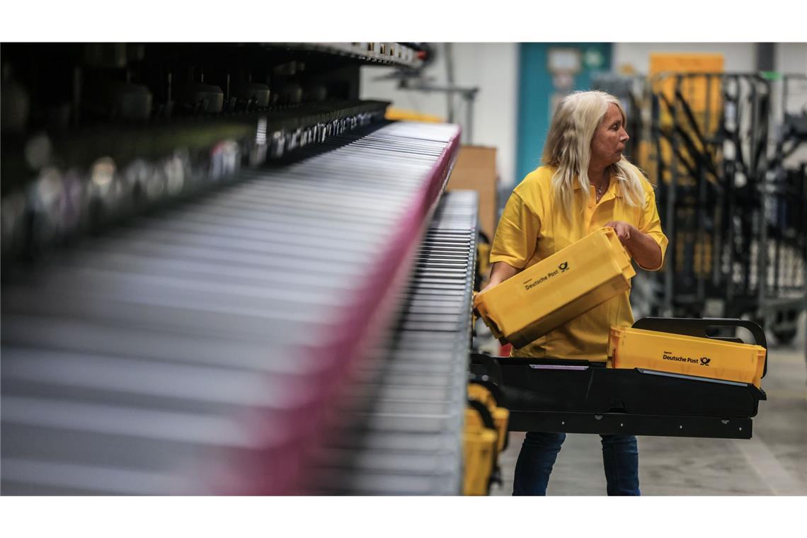 Eine Mitarbeiterin der Deutschen Post DHL sortiert Briefe im Briefverteilzentrum Frechen in Nordrhein-Westfalen.