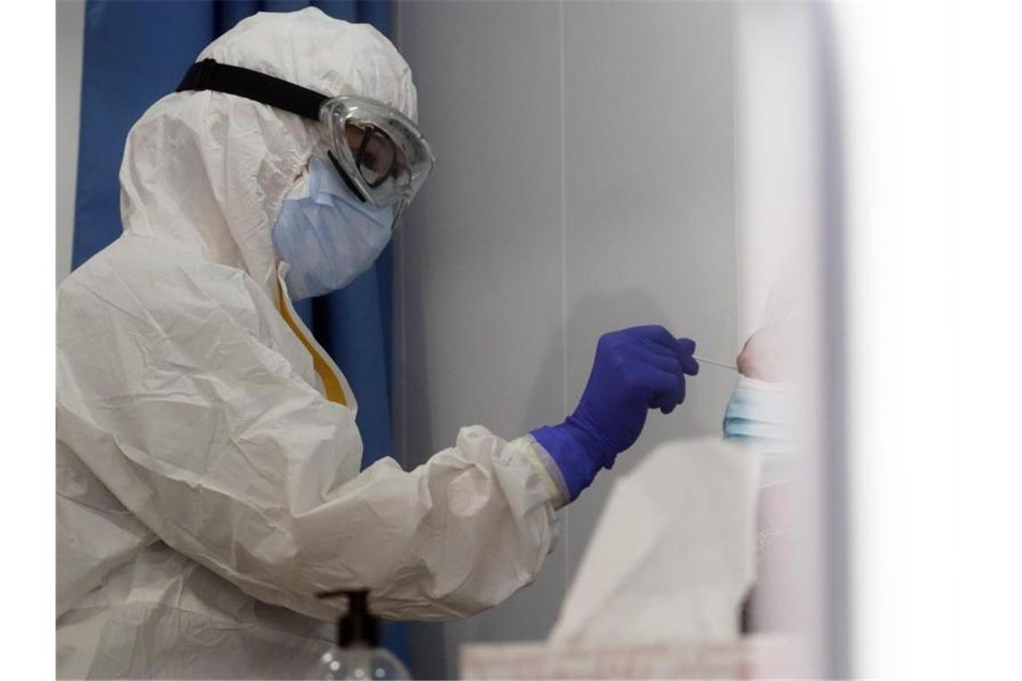Sieben-Tage-Inzidenz sinkt weiter Eine Mitarbeiterin des Gesundheitswesens nimmt von einer Frau einen Abstrich für einen Corona-Test. Foto: Álex Zea/EUROPA PRESS/dpa