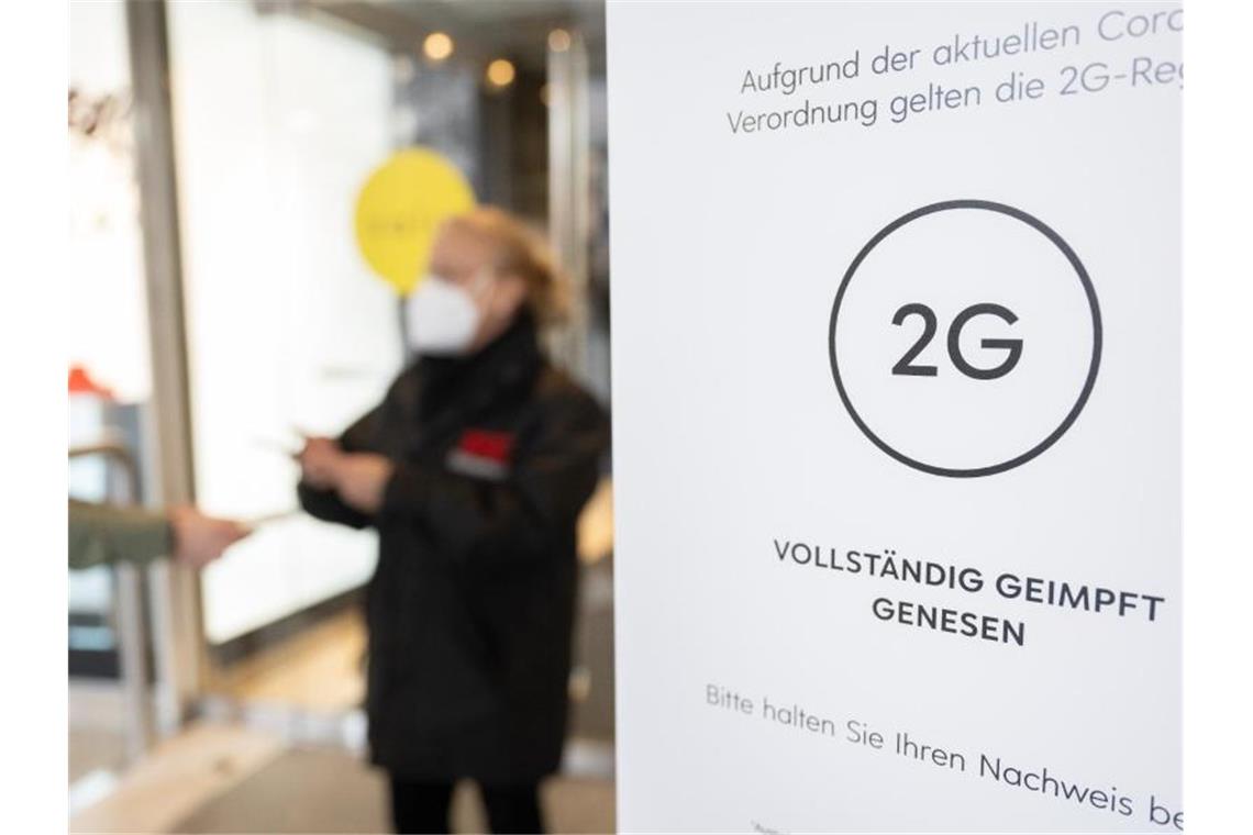Lebensmittelketten: Ende der 2G-Regel im übrigen Handel Eine Mitarbeiterin eines Stuttgarter Kaufhauses kontrolliert den Impfnachweis einer Kundin. Foto: Bernd Weißbrod/dpa