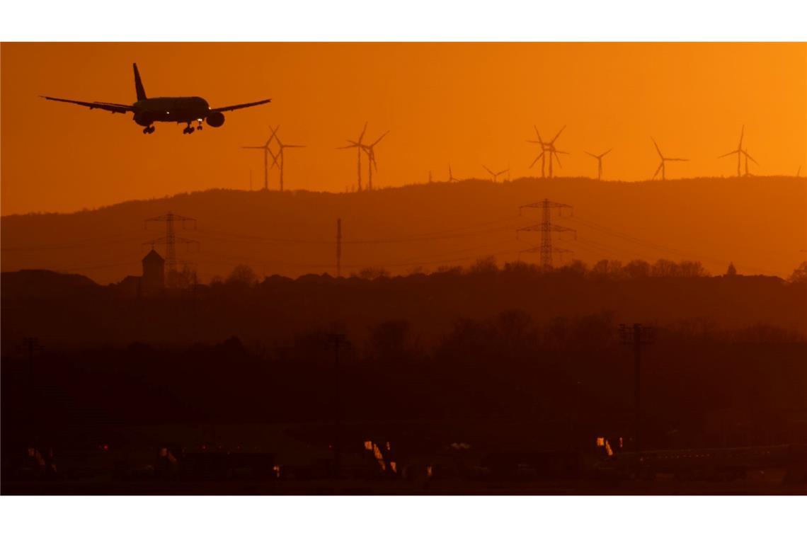 Eine Passagiermaschine befindet sich im letzten Licht des Tages im Landeanflug auf den Flughafen Frankfurt.