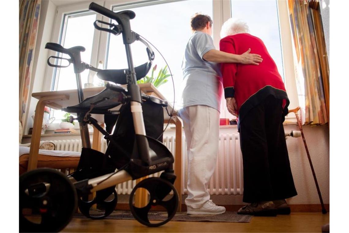 Eine Pflegerin und eine Bewohnerin des Pflegeheims schauen aus dem Fenster. Foto: Tom Weller/dpa/Symbolbild