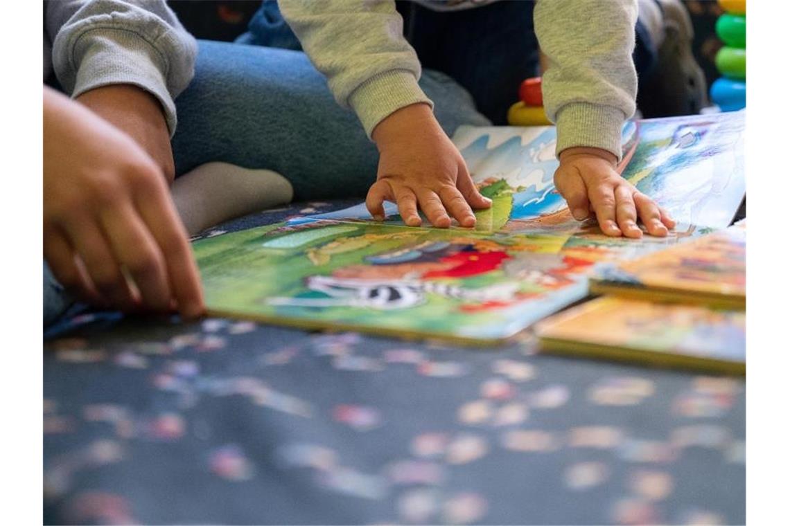 Eine Praktikantin liest in einer Kita Kindern vor. Foto: Sebastian Gollnow/dpa/Illustration