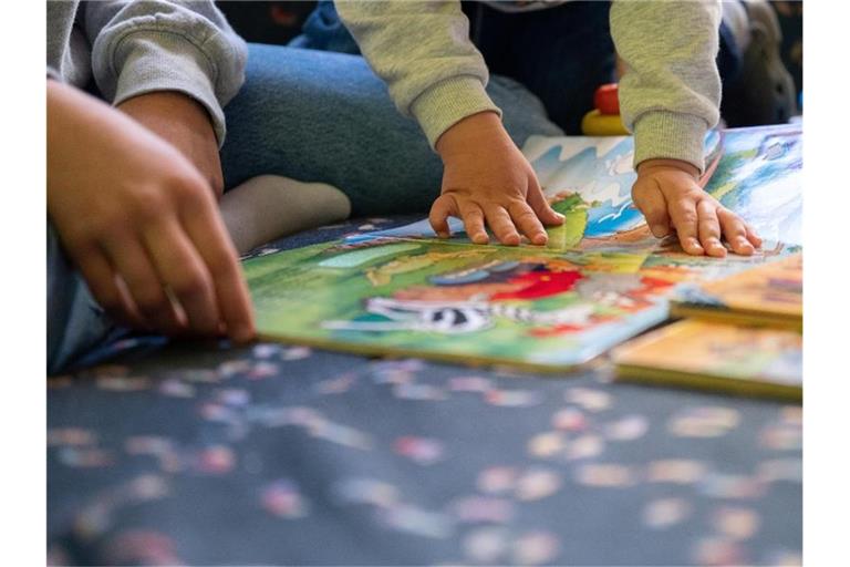 Eine Praktikantin liest in einer Kita Kindern vor. Foto: Sebastian Gollnow/dpa/Illustration