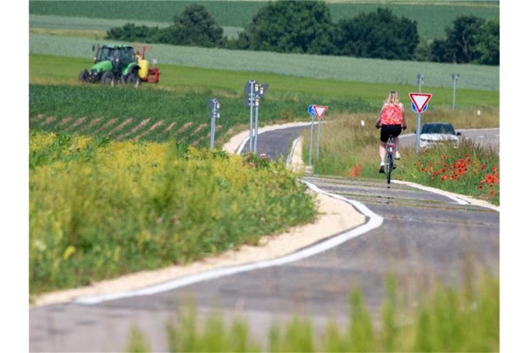 Eine Radfahrerin fährt auf dem neuerrichteten Radweg zwischen dem bayerischen Bachhagel und Ballmertshofen. Foto: Stefan Puchner/dpa