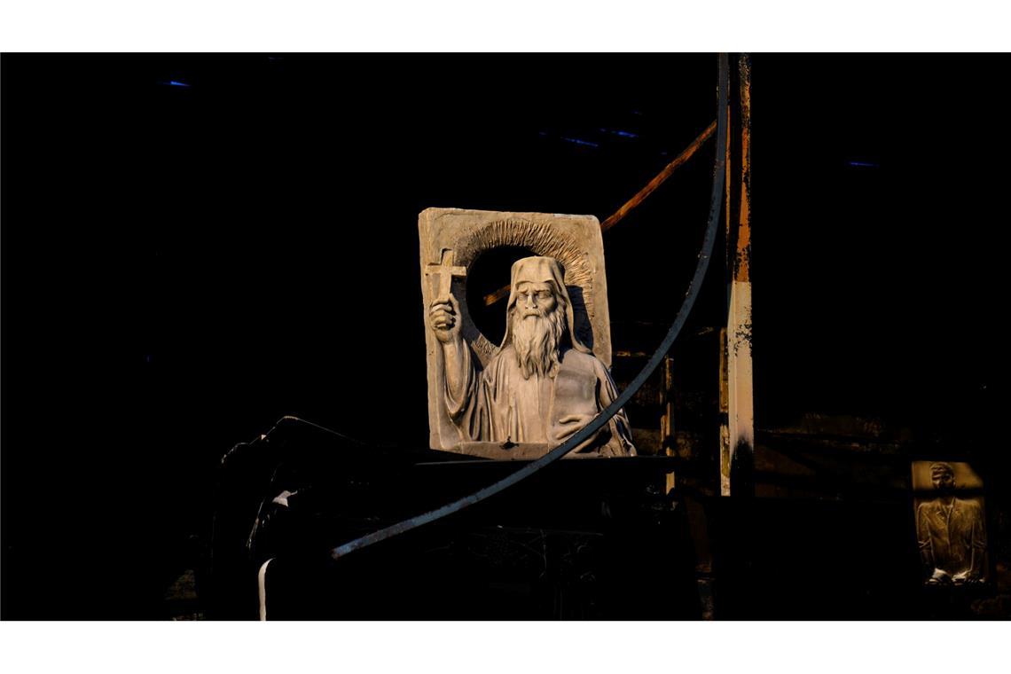 Eine religiöse Skulptur steht in einer verbrannten Werkstatt in Chalandri, einem Vorort von Athen, nach einem Waldbrand nahe der griechischen Hauptstadt.