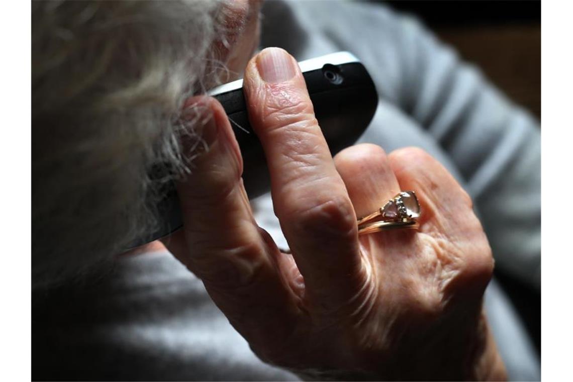 Eine Rentnerin hält ein Telefon in der Hand. Foto: Karl-Josef Hildenbrand/dpa/Symbolbild