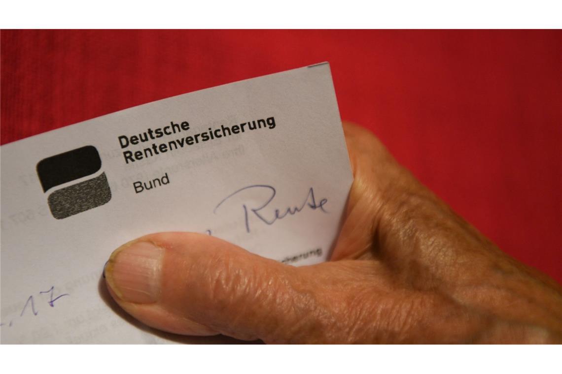 Eine Rentnerin hält ihren Rentenbescheid in der Hand.