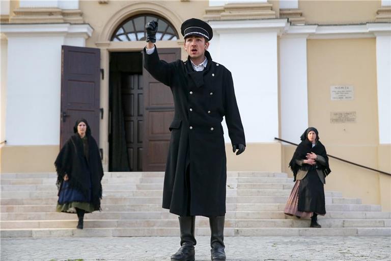 Eine Schlüsselszene im Theaterstück „Schweres Gepäck“: Der Büttel verkündet die Vertreibung vor der Kirche. Foto: Dénes Mártonfai