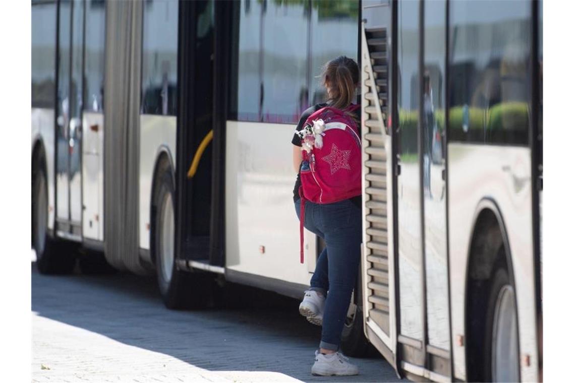 In den Kosten-Streit um Schülerbeförderung kommt Bewegung Eine Schülerin steigt an einer Bushaltestelle in einen Bus ein. Foto: Marijan Murat/dpa