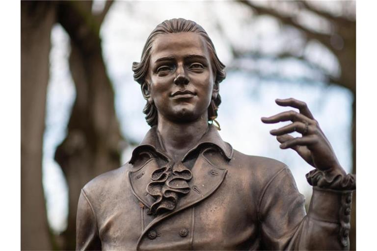 Eine Skulptur, die Friedrich Hölderlin darstellt, steht vor Bäumen. Foto: Marijan Murat/dpa/Archivbild