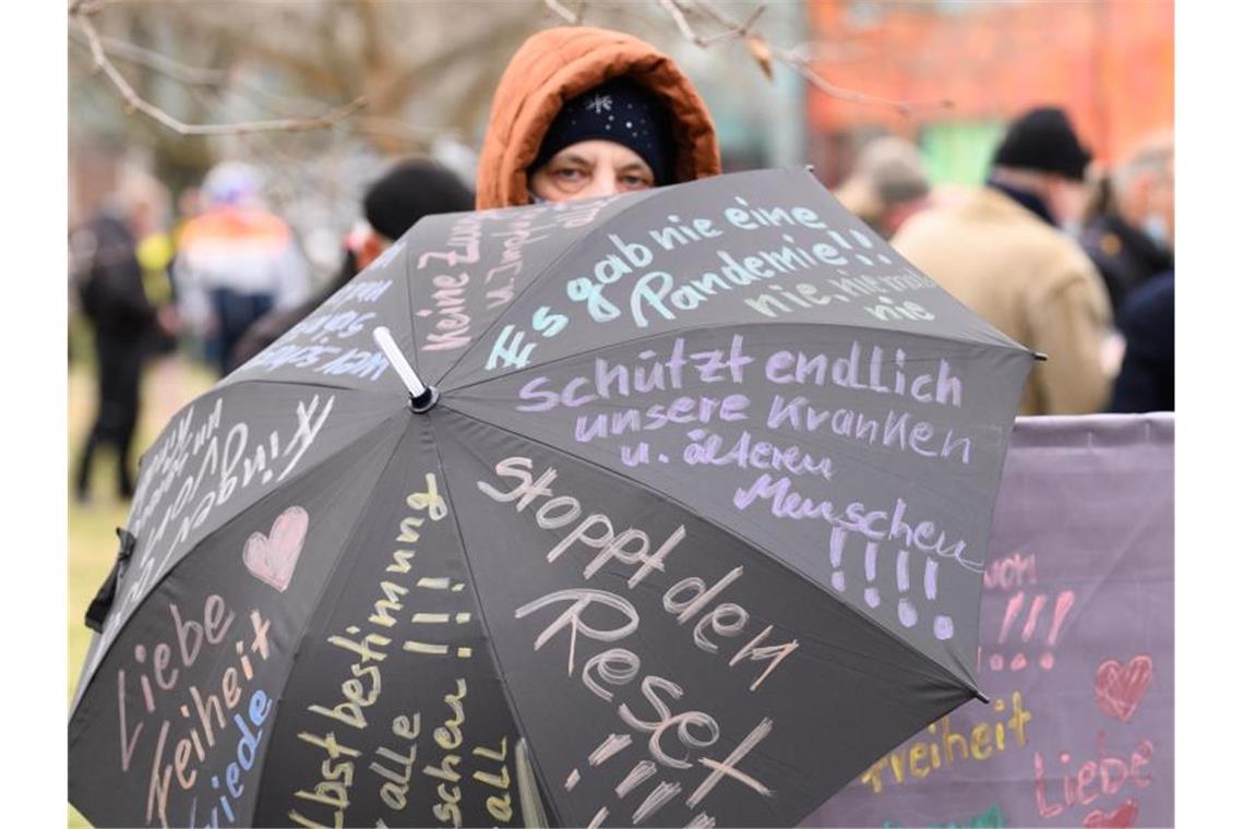 Demo in Dresden: Rund 50 Straftaten gezählt Eine Teilnehmerin der Proteste in Dresden hat ihre Forderungen auf einen Regenschirm geshrieben. Foto: Sebastian Kahnert/dpa-Zentralbild/dpa