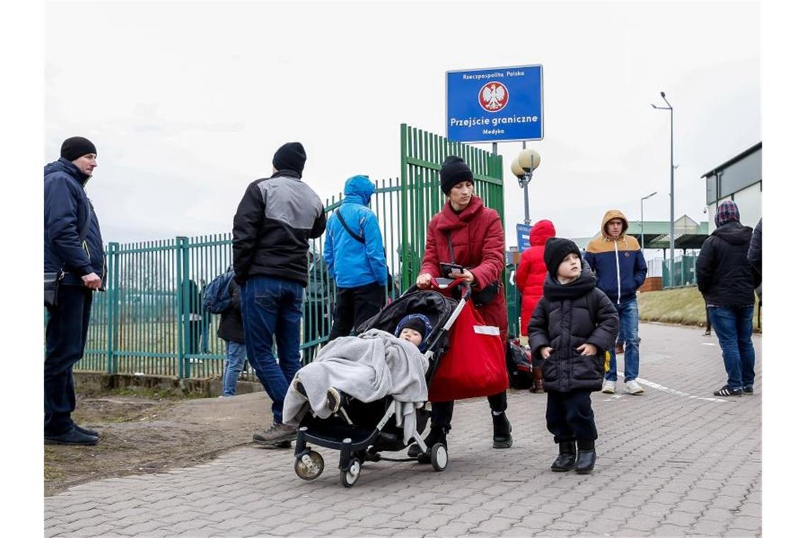 Eine ukrainische Familie geht durch den Grenzübergang nach Polen. Foto: Dominika Zarzycka/SOPA Images via ZUMA Press Wire/dpa